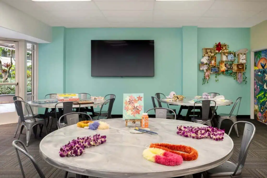Table, chairs with arts, crafts, TV on wall