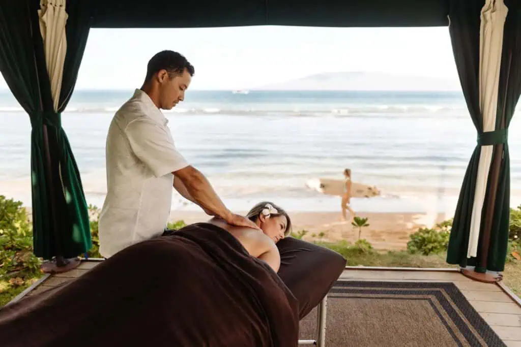 Woman having massage treatment in beachside cabana