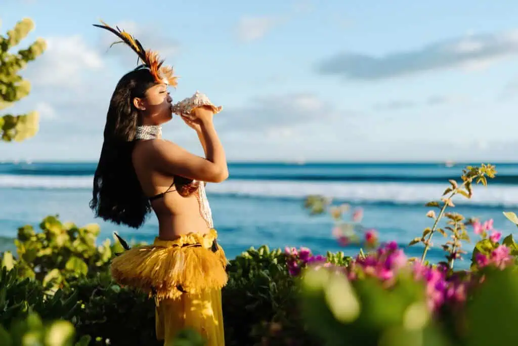 Hawaiian woman dancer blowing in seashell