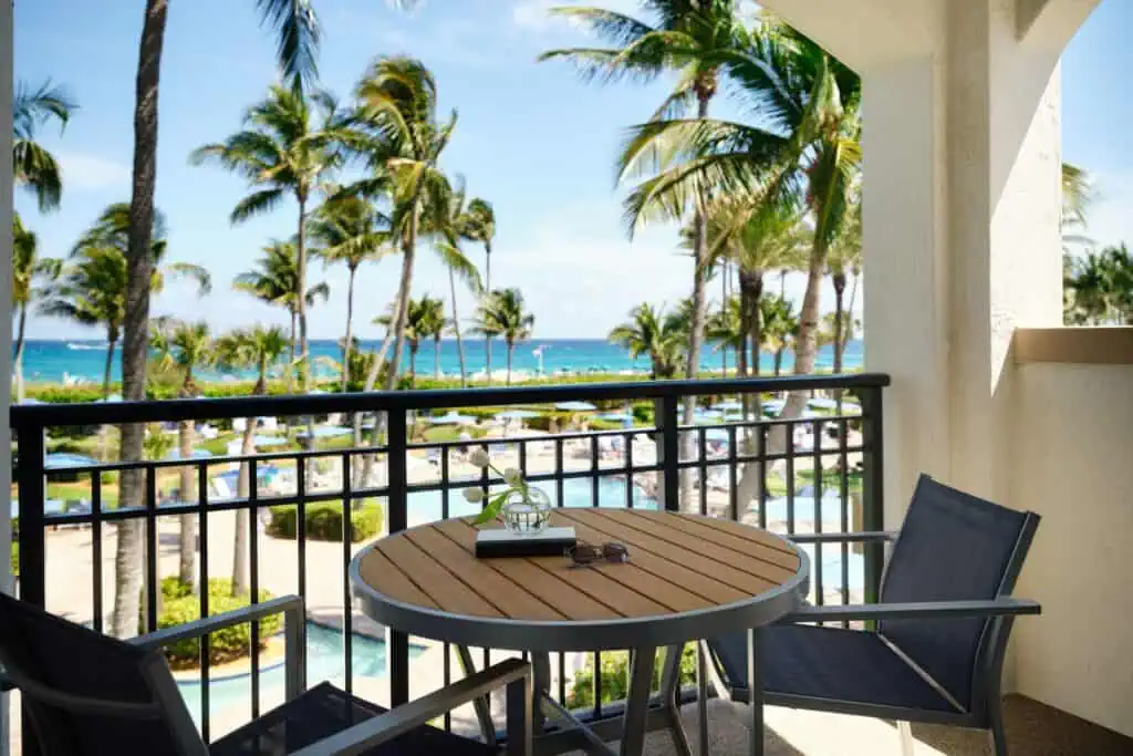 Balcony with table and chairs looking toward ocean