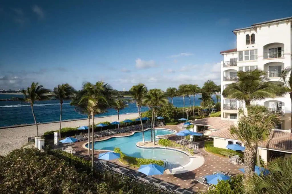Pool with lounge chairs, umbrellas, near ocean
