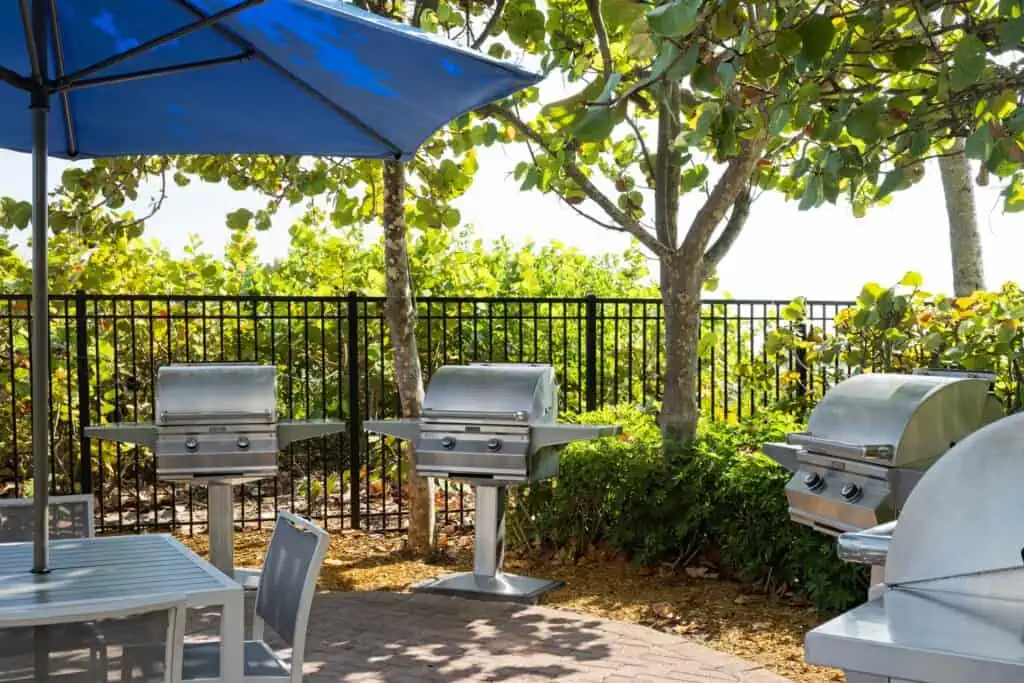 Four outdoor grills, table with umbrella